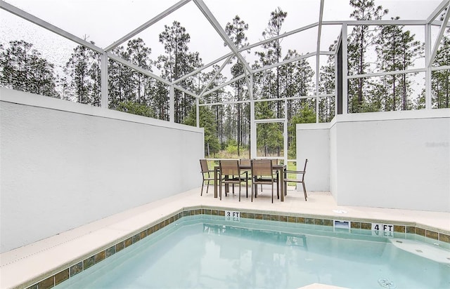 view of pool with a patio and glass enclosure