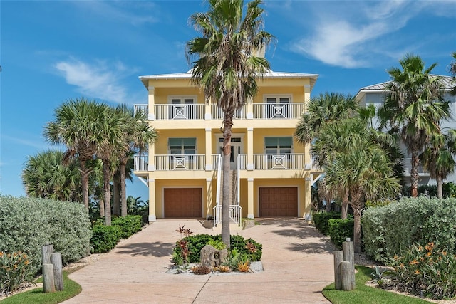 coastal home featuring a balcony and a garage