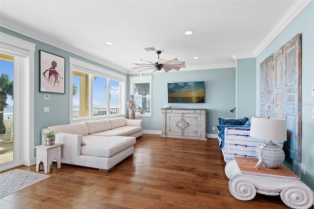 living room featuring ornamental molding, dark wood-type flooring, a textured ceiling, and ceiling fan