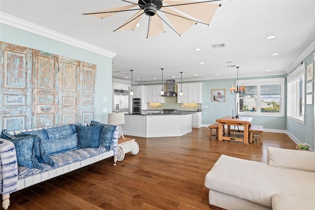 living room with crown molding, sink, ceiling fan with notable chandelier, and dark hardwood / wood-style flooring