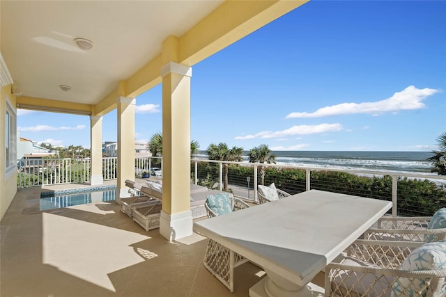 view of patio with a water view and a beach view