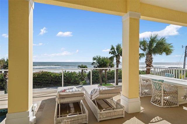 balcony with outdoor lounge area, a water view, and a beach view