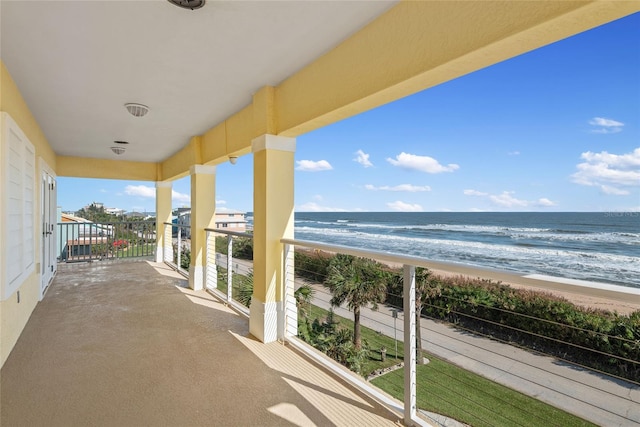 balcony with a water view and a beach view