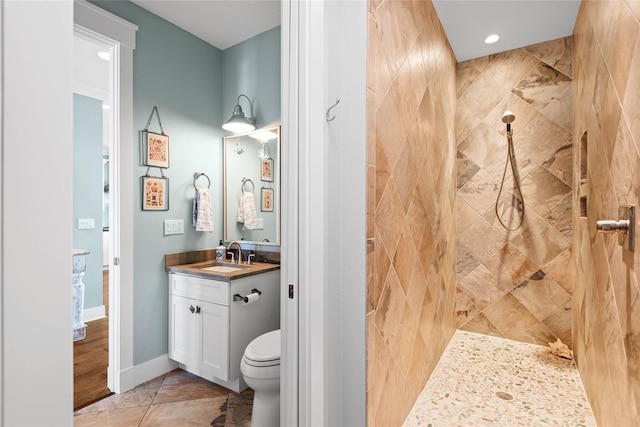 bathroom with vanity, a tile shower, tile patterned floors, and toilet