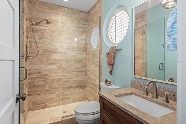 bathroom featuring vanity, toilet, and an enclosed shower