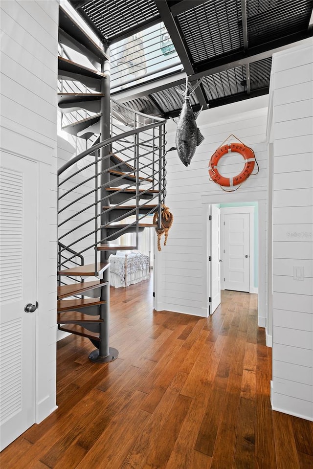 staircase featuring hardwood / wood-style floors and wooden walls