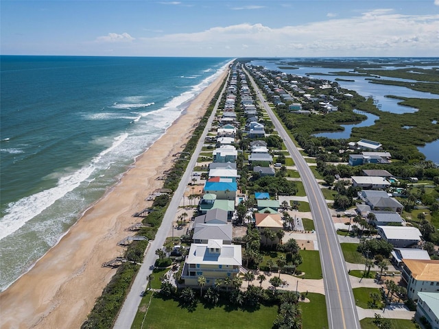 birds eye view of property featuring a water view and a beach view