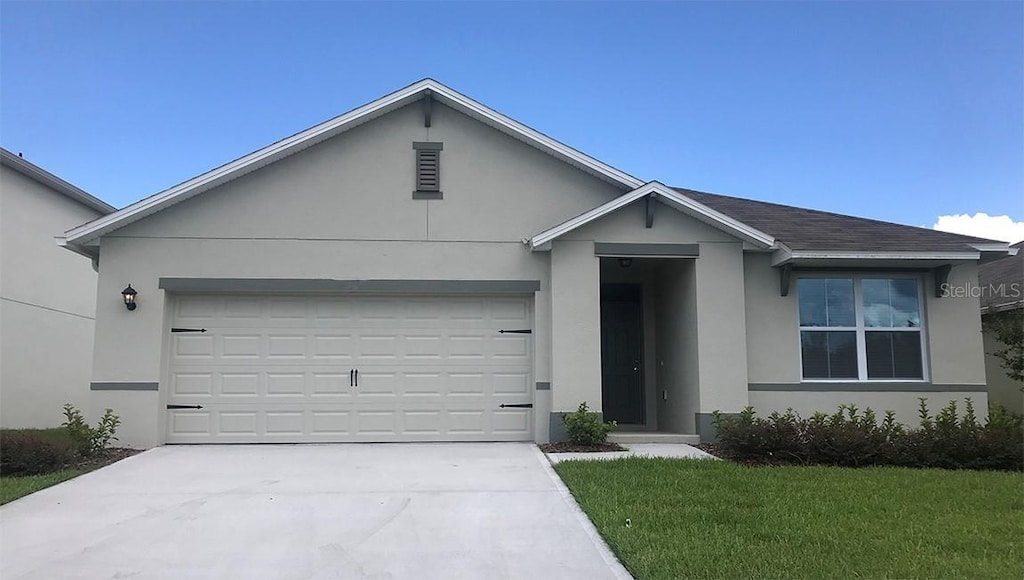 single story home featuring a garage and a front yard