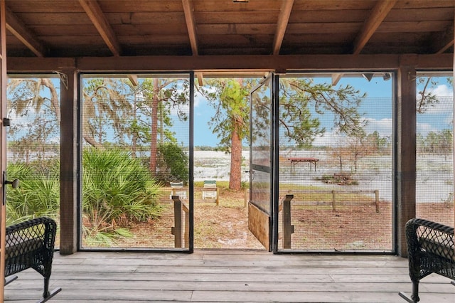 unfurnished sunroom with beamed ceiling, a wealth of natural light, and wooden ceiling