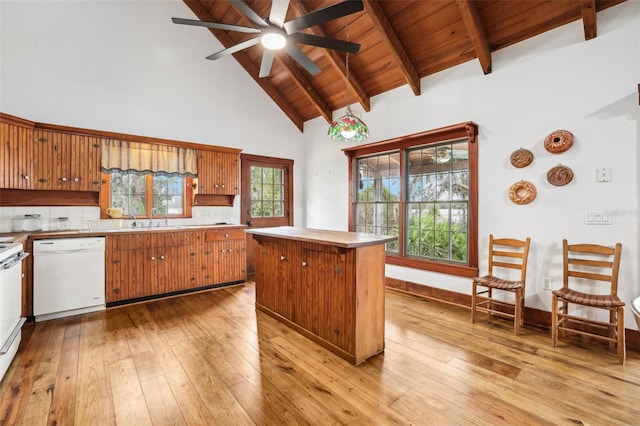 kitchen with white dishwasher, a center island, beam ceiling, and light hardwood / wood-style flooring