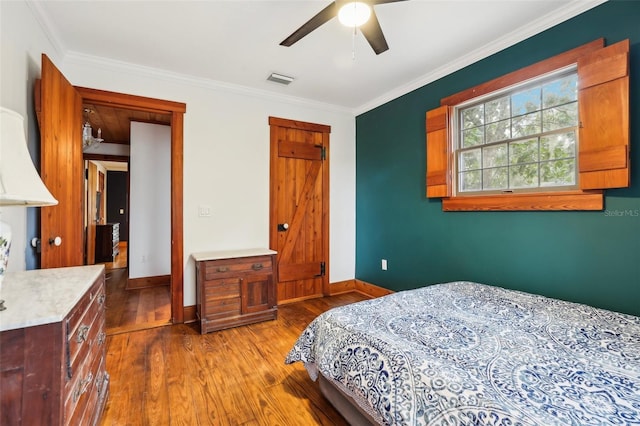 bedroom with hardwood / wood-style flooring, ceiling fan, and crown molding