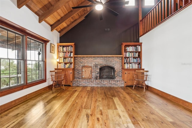 living area featuring baseboards, wooden ceiling, a ceiling fan, hardwood / wood-style flooring, and beam ceiling