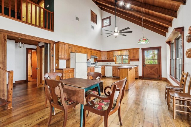 dining room with vaulted ceiling with beams, light wood-style flooring, visible vents, and a ceiling fan