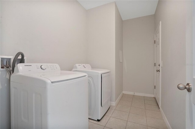 laundry area featuring washer and clothes dryer and light tile patterned floors