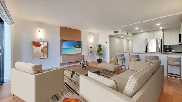 living room with light wood-type flooring and sink