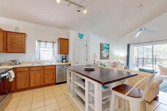 kitchen with sink, light tile patterned flooring, stainless steel appliances, and ceiling fan