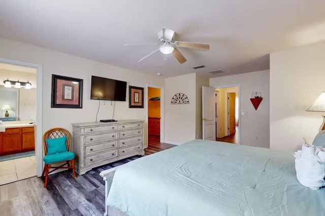 bedroom featuring ensuite bathroom, dark hardwood / wood-style flooring, and ceiling fan