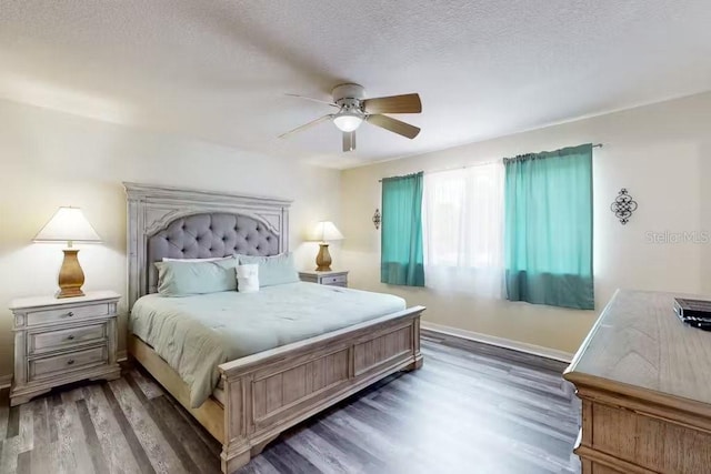 bedroom featuring dark hardwood / wood-style flooring, a textured ceiling, and ceiling fan