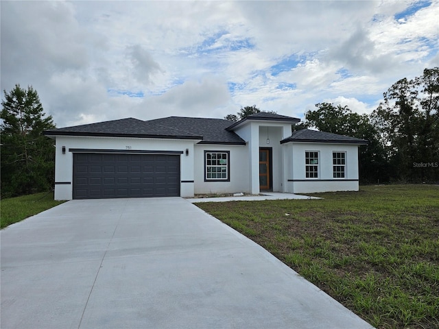 view of front of home with a front yard and a garage