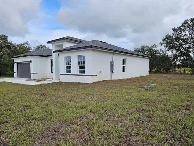 view of side of property with a yard and a garage