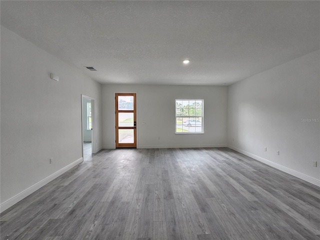 empty room featuring a textured ceiling and wood-type flooring