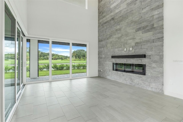 unfurnished living room featuring a towering ceiling and light tile patterned floors