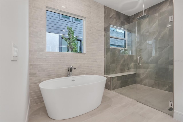 bathroom featuring tile patterned floors, shower with separate bathtub, and tile walls