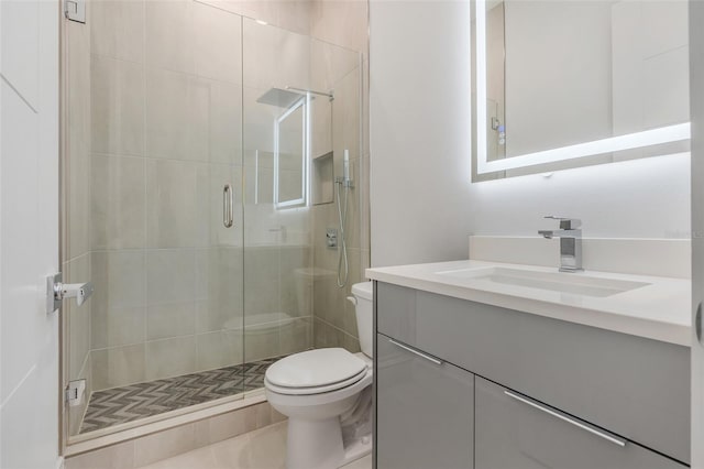 bathroom featuring vanity, toilet, tile patterned floors, and a shower with shower door