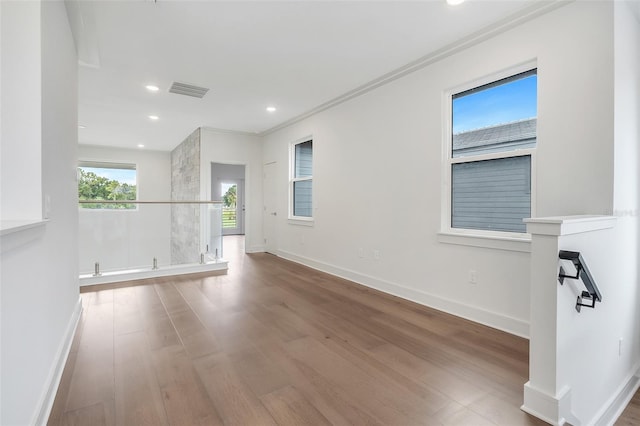 empty room featuring crown molding and hardwood / wood-style flooring