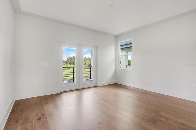 unfurnished room featuring french doors, wood-type flooring, and ornamental molding