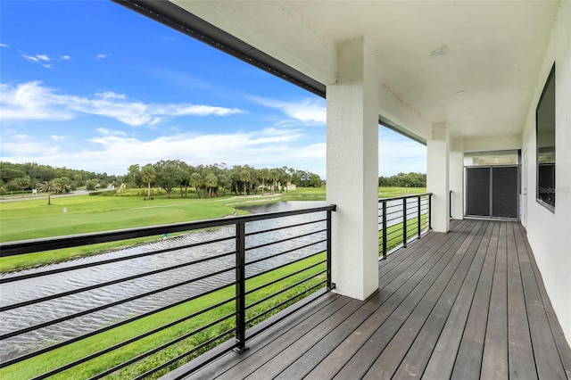 wooden deck featuring a water view and a lawn