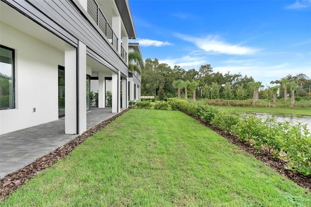 view of yard with a balcony and a patio