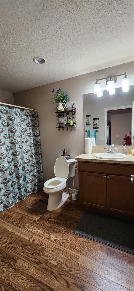 bathroom with vanity, hardwood / wood-style floors, toilet, and a textured ceiling