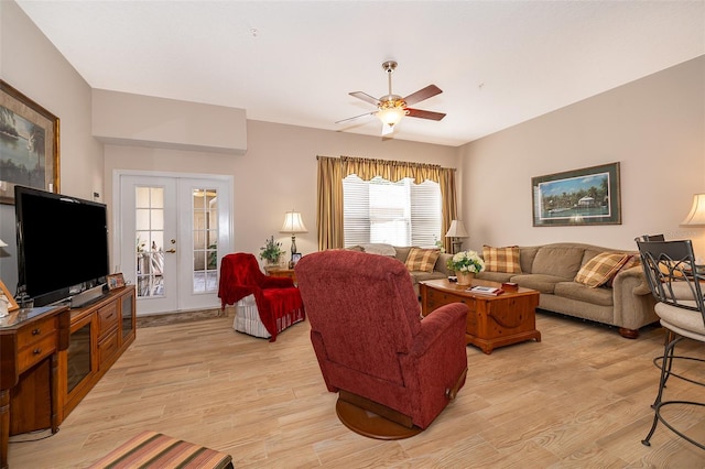 living room featuring light wood-type flooring, ceiling fan, and french doors