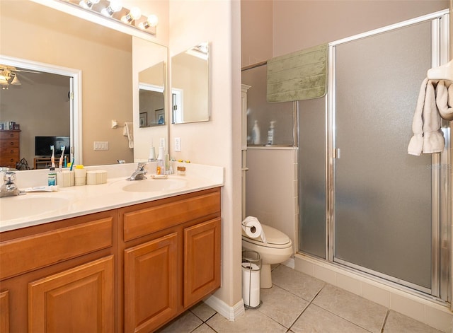 bathroom featuring vanity, toilet, a shower with door, and tile patterned floors