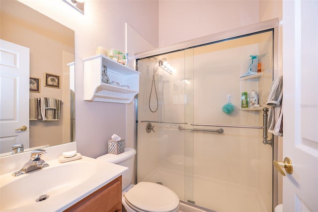 bathroom featuring vanity, walk in shower, and toilet