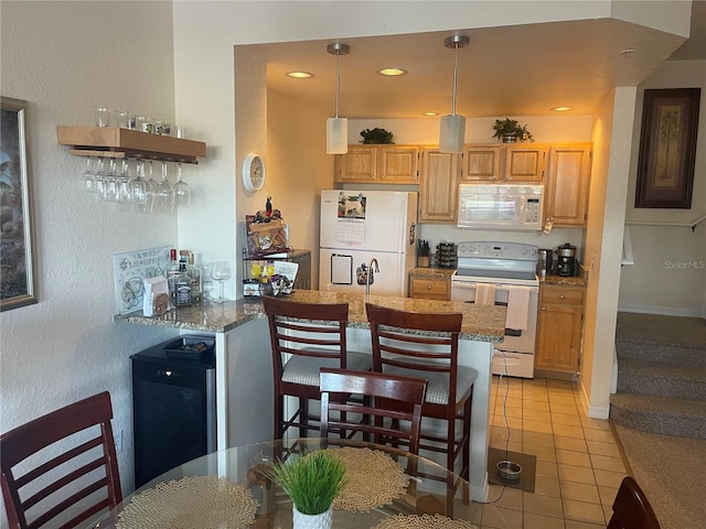 kitchen featuring kitchen peninsula, decorative light fixtures, light tile patterned floors, light stone counters, and white appliances