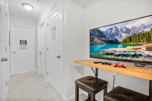 hall featuring light colored carpet