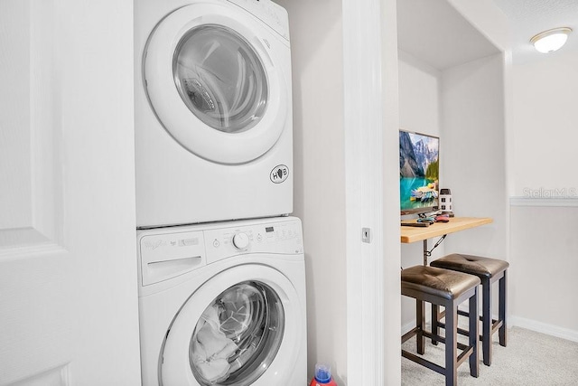 laundry area with stacked washer / dryer and light colored carpet