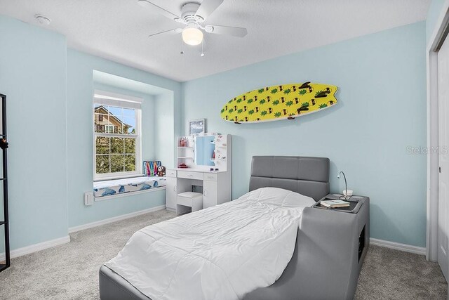 bedroom with ceiling fan, baseboards, and carpet flooring