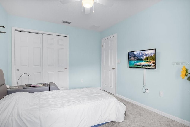 bedroom with baseboards, visible vents, ceiling fan, carpet, and a closet