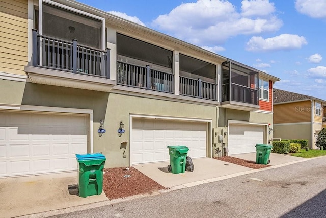 view of front of property with a garage, a balcony, and stucco siding