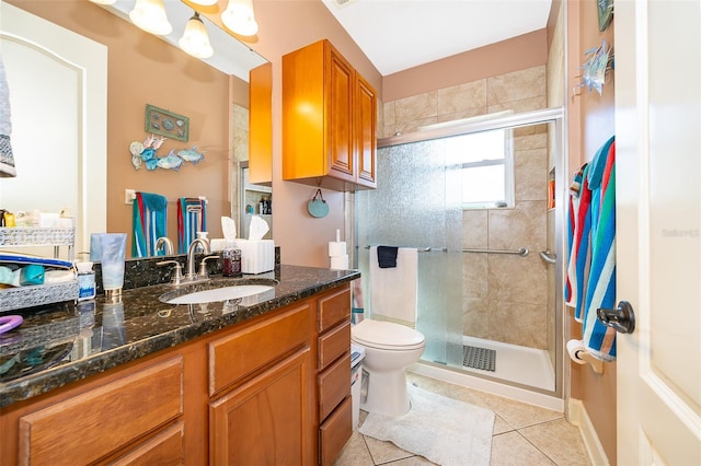 bathroom with vanity, tile patterned flooring, toilet, and a shower with door