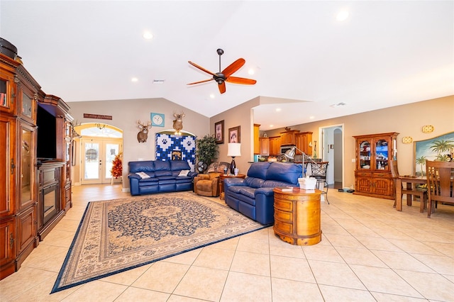 tiled living room with ceiling fan, vaulted ceiling, and french doors