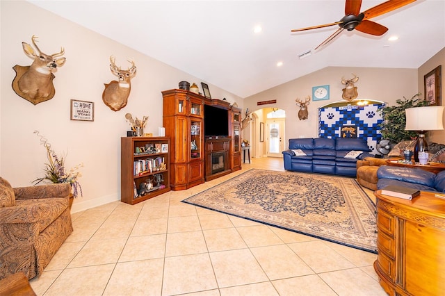 living room featuring ceiling fan, light tile patterned floors, and vaulted ceiling