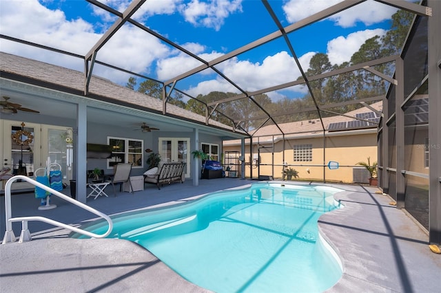 view of swimming pool with french doors, a patio, a lanai, and ceiling fan