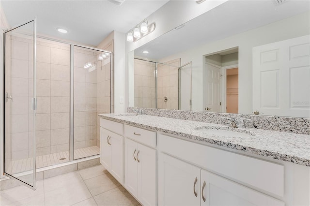 bathroom featuring vanity, a shower with shower door, and tile patterned flooring