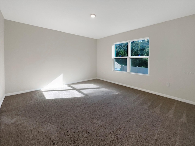 empty room with dark colored carpet