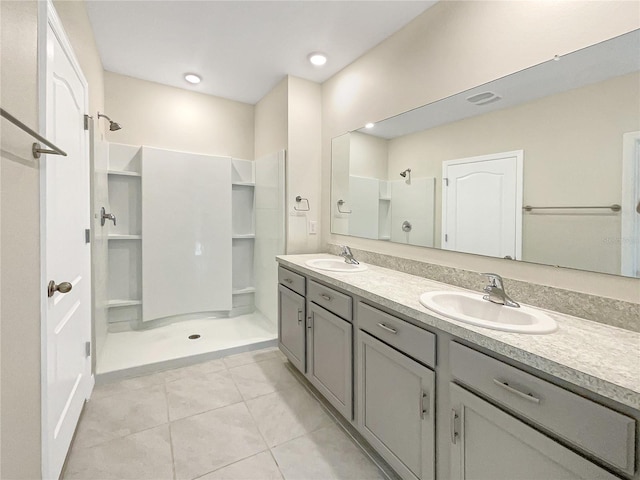 bathroom with walk in shower, vanity, and tile patterned floors