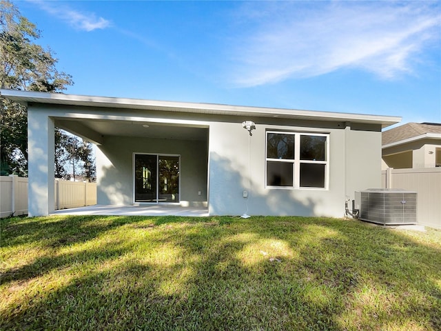 rear view of property with a patio, a lawn, and central AC unit